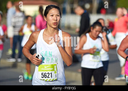 Committed Asian Female Athlete Running In The Nike Woman's Half Marathon, San Francisco, 2015. Stock Photo