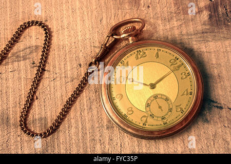 Old pocket Watch with chain on wooden table Stock Photo