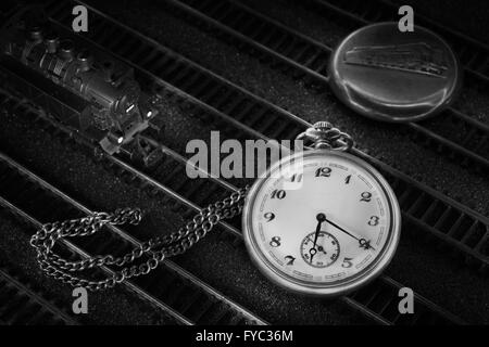 Pocket watch with train, locomotive, cover and chain on rails Stock Photo