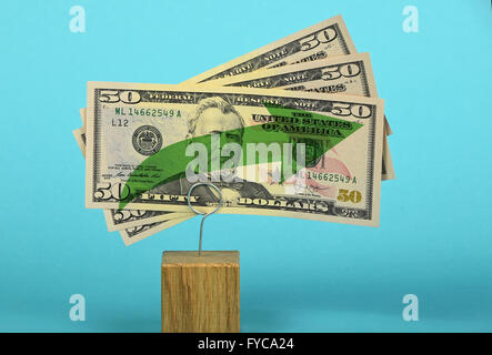 Growth and support of American economy and US dollar, tree fifty dollars banknote with green arrow up on two holders over blue b Stock Photo