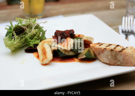 Vegetarian Starter of food, Greek meal of Halloumi, roasted vegetables and crusty bread on white plate Stock Photo