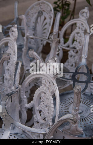 Stacked white wrought iron chairs. Tarnished and shabby outdoor furniture.  La Habana, Old Havana, Cuba Stock Photo