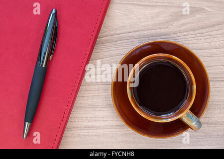 Coffee cup and notebook with pen on wood desk Stock Photo
