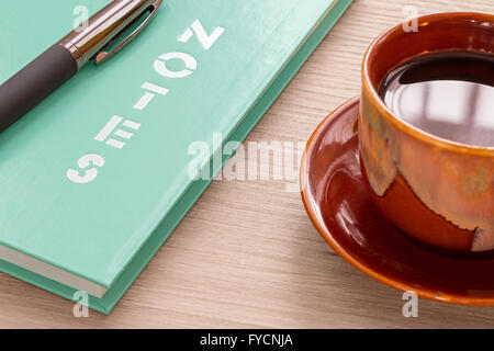 Coffee cup and notebook with pen on wood desk Stock Photo