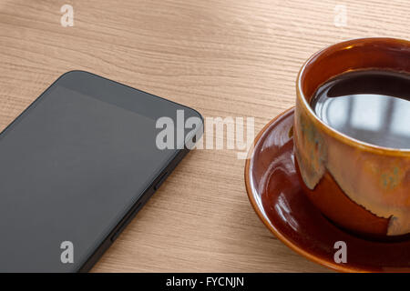 Coffee cup and smartphone on wood desk Stock Photo