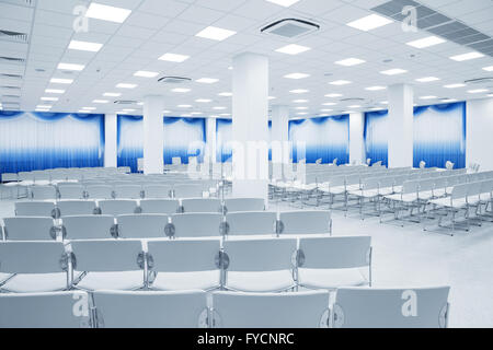 large and modern white auditorium with blue curtains Stock Photo
