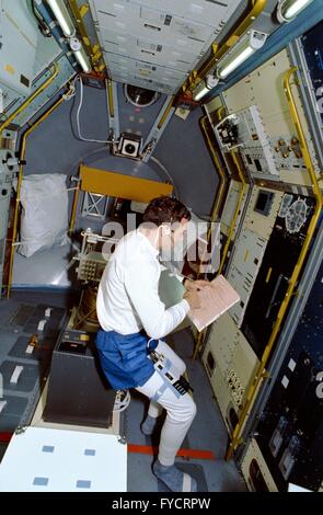 NASA astronaut David Hilmers looks over a checklist in the science module aboard the Space Shuttle Discovery mission STS-42 January 22, 1992 in Earth Orbit. Stock Photo