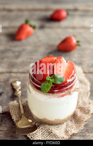 Strawberries cheesecake in the jar on wooden background,selective focus Stock Photo