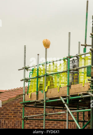 Abandoned hard hat on scaffolding Stock Photo