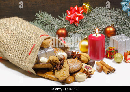 Christmas sack with Christmas cookies, biscuits, gingerbread, gifts and Christmas decorations in the snow Stock Photo