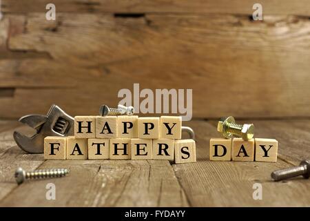 Happy Fathers Day blocks with tools on a rustic wood background Stock Photo