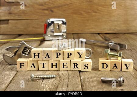 Happy Fathers Day blocks with tools on a rustic wood background Stock Photo