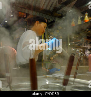 Female Chef cooking food in steamy Chinese Restaurant in China Town, Soho, London, England Stock Photo