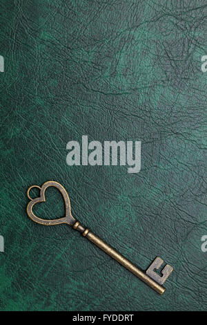 vintage key heart shape on green leather background Stock Photo - Alamy