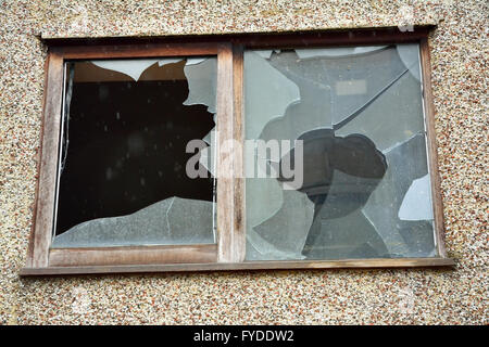 Broken window caused by vandalism and rain getting in Stock Photo