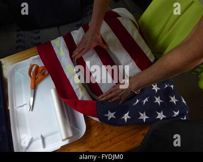 Philadelphia, Pennsylvania, USA. 25th Apr, 2016. New York artist MARY MIHELIC and Philadelphia artist David Gleesen drove a former Trump-Campaign bus turned art installation to the April 25, 2016 Trump rally. Inside the bus Mihelic is seen working on art project as she embroiders American Flags with phrases Trump said during his campaign. Trump-Supporters and anti-Trump protestors face each other outside a rally of the Republican candidate, held at the campus of West Chester University in West Chester, Pennsylvania a day ahead of the Pennsylvania Primary. (Credit Image: © Bastiaan Slabbers Stock Photo