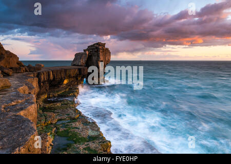 Portland Bill, Dorset, UK. 26th April 2016.  UK Weather - Stormy looking clouds are illuminated by the setting sun above Pulpit Rock at Portland Bill on the Jurassic Coast of Dorset - Picture: Graham Hunt /Alamy Live News Stock Photo
