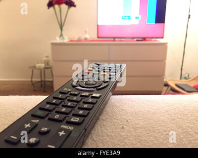 Close up of a remote controller with a television on background Stock Photo