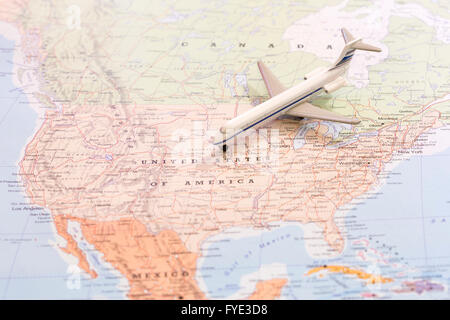 Miniature of a passenger airplane flying on the map of United States of America from north east. Conceptual image for travel and Stock Photo