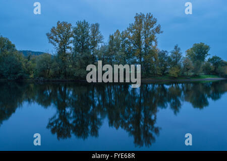 Autumn Trees Reflecting in a river in the Dordogne region of France Stock Photo