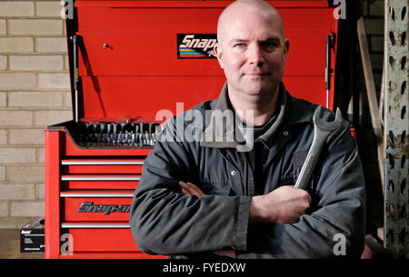male motor mechanic standing in front of tool box Stock Photo