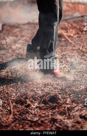 Legs of the person extinguish fire. Stock Photo