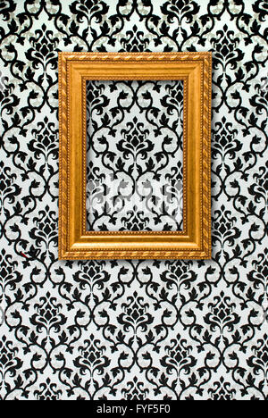 Gold frame on a black and white wallpaper Stock Photo