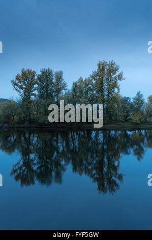 Trees reflecting in a river in Beynac, dordogne region, France Stock Photo