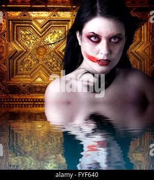 Woman vampire with blood in his mouth. Gothic Image halloween over gold background  in the water reflection Stock Photo