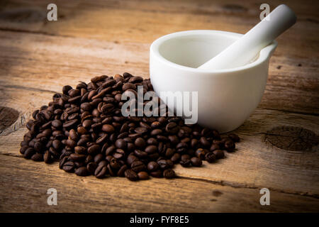 Coffee beans on rustic wooden background and white mortar Stock Photo