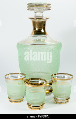 green glass carafe and three glasses on a white background Stock Photo