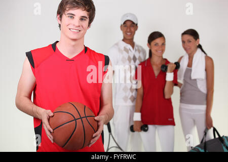 A basketball player posing with other athletes Stock Photo