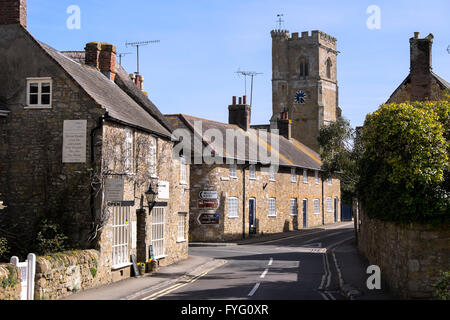 View along the main street in Abbotsbury with the church of St Nicholas in the background Stock Photo