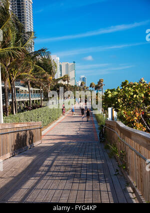 Runners and walkers on the Miami Beach Boardwalk in South Beach. Stock Photo