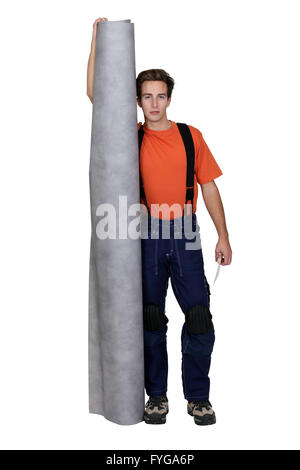 Tradesman holding a roll of linoleum flooring Stock Photo