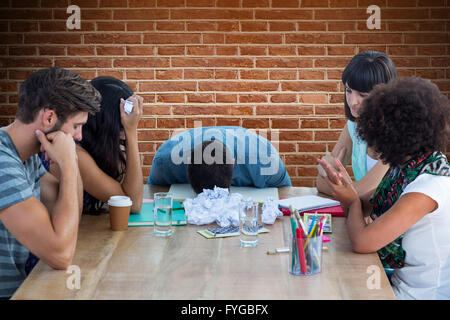 Composite image of exhausted creative business team in meeting Stock Photo