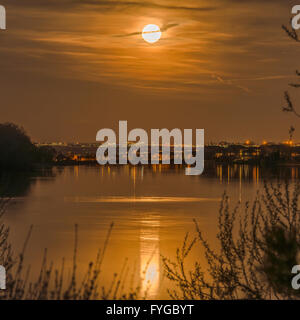 Full Moon Night - Bright full moon shining over a lake-side neighborhood. Stock Photo