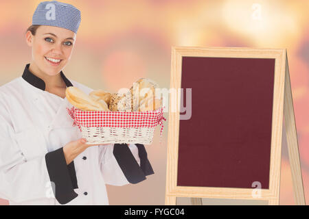 Composite image of woman in chef uniform with bread basket Stock Photo