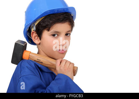 little boy dressed as a craftsman holding a hammer Stock Photo