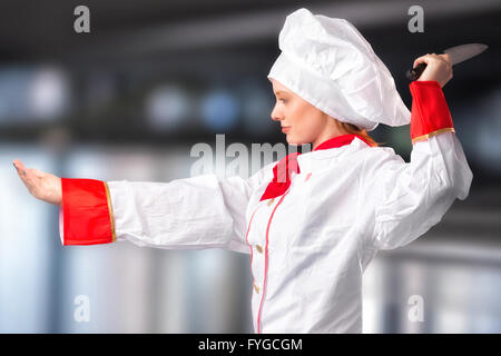 Composite image of pretty chef slicing with knife Stock Photo