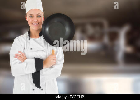 Composite image of female chef with arms crossed holds frying pan Stock Photo