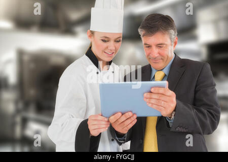 Composite image of businessman and female chef using digital tablet Stock Photo
