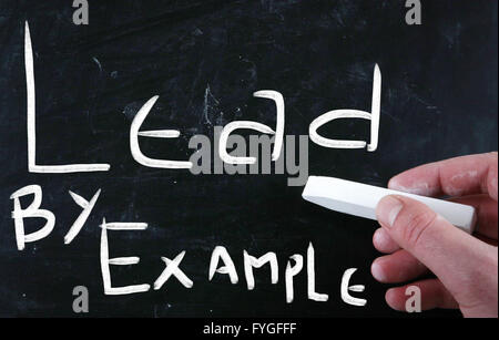 Lead by example handwritten with white chalk on a blackboard Stock Photo