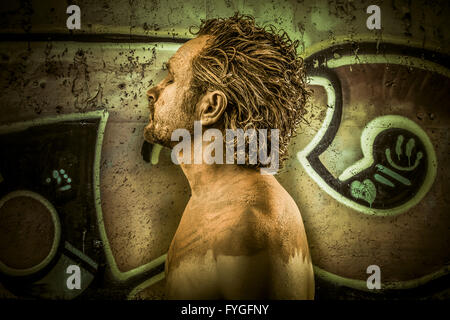 Warrior man covered in mud on grafitti background Stock Photo