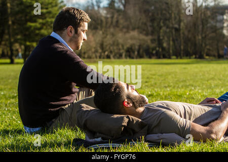 Cardiff, United Kingdom. February 18 2016. Cold snap? What cold snap? Two friends enjoy the sunny weather in Bute Park, Caridff. Stock Photo