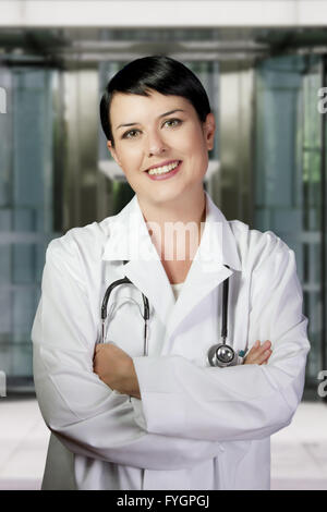 Young doctor in white uniform against technology background Stock Photo