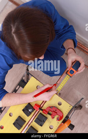 a female technician working on a copper tube Stock Photo