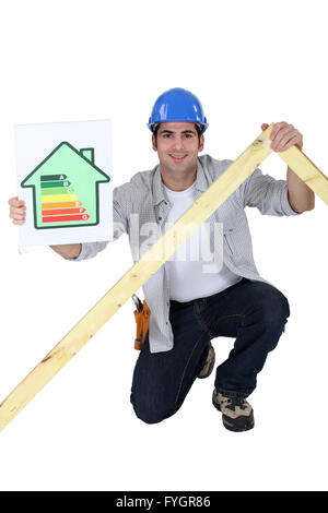 Tradesman holding a frame and an energy efficiency rating chart Stock Photo