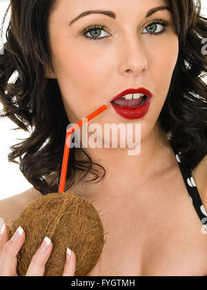 Healthy Fit Young Woman Holding and Drinking From A Fresh Coconut Isolated Against A White Background Stock Photo