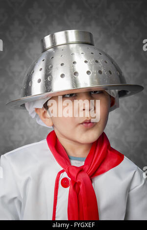 A funny little boy cook in uniform over vintage  background Stock Photo